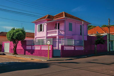 Colorful corner townhouse in an empty street and sunny day at sao manuel, brazil.