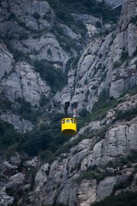 View of overhead cable car against rocky mountain