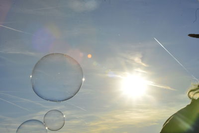 Low angle view of young woman blowing bubbles