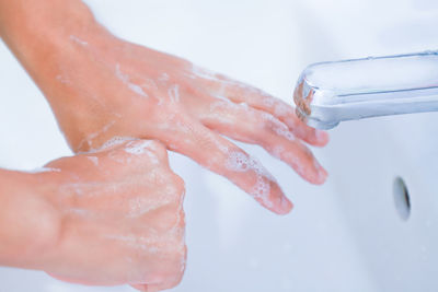 Close-up of hand holding wet leaf