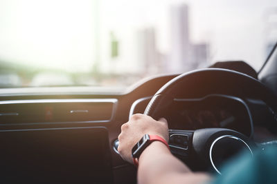 Cropped hand of man driving car