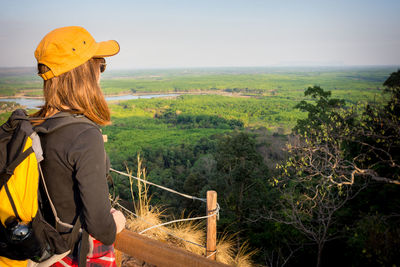 Rear view of woman standing on landscape against sky