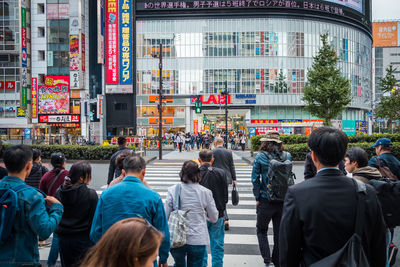 Crowded people are walking and shopping at a street in shinjuku town.
