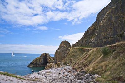 Rock formations by sea against sky