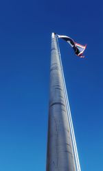 Low angle view of person paragliding against clear blue sky