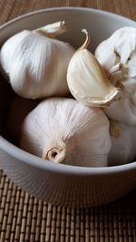 Close-up of garlic in bowl on place mat