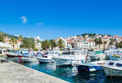 Boats moored on sea against blue sky