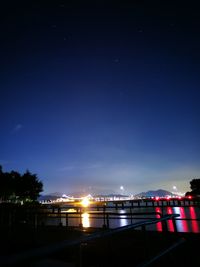 Illuminated city against sky at night