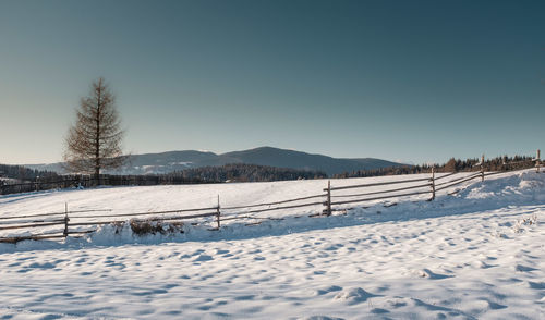 Snow covered field against sky