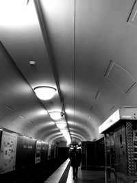 Woman walking in illuminated tunnel