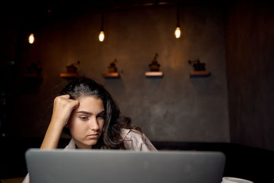 Side view of woman using laptop at home