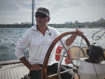 Man wearing sunglasses against sea against sky