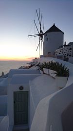 Traditional windmill on beach at sunset