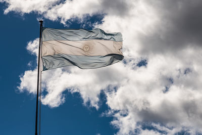 Low angle view of flag against cloudy sky