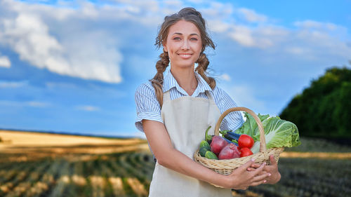 Portrait of young woman holding ice cream while standing in basket