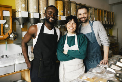 Portrait of smiling multiracial colleagues standing in food store