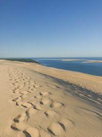 Scenic view of beach against clear blue sky