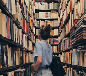 Woman standing amidst books in store