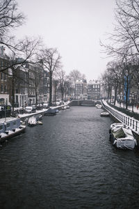 Canal in city against sky