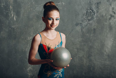 Portrait of girl standing against wall