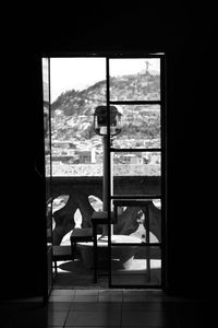 Woman sitting on bed seen through window