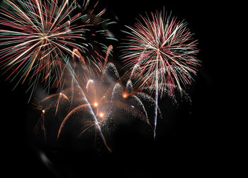 Low angle view of firework display at night