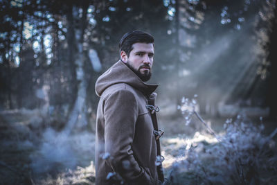 Portrait of young man in forest during winter