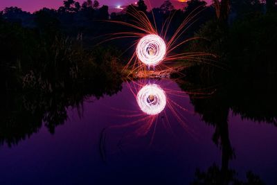 Illuminated firework display in sky at night