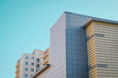 Low angle view of buildings against clear blue sky