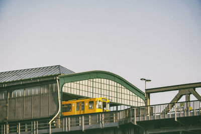 Low angle view of train at railroad station against clear sky