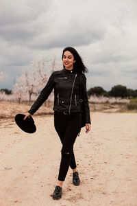 Full length of woman walking on field against sky