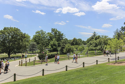 Group of people playing soccer on field against sky