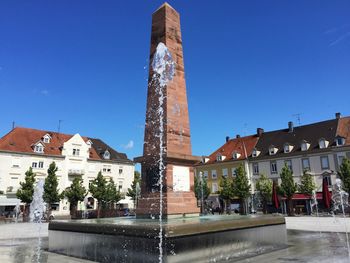 Low angle view of fountain against buildings in city