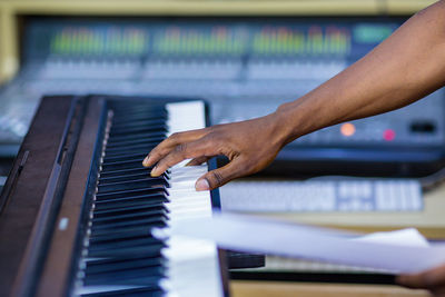 Cropped hand of woman playing piano