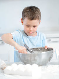 Portrait of cute baby boy eating food at home