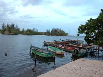 Boats moored in lake against sky