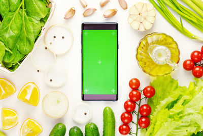 Vegetables and smartphone with green screen on a white background. the concept of online purchases 