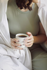 Midsection of woman holding coffee