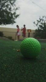 Two people playing soccer ball on ground