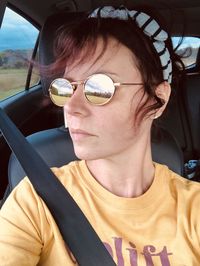 Portrait of man wearing sunglasses in car