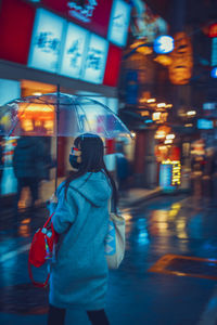 Woman standing on city street during rainy season