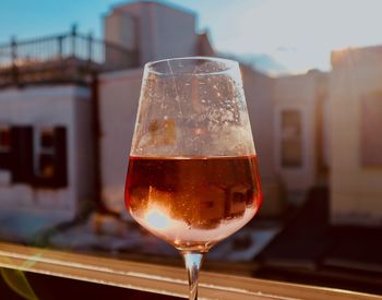 Close-up of beer glass on table against building