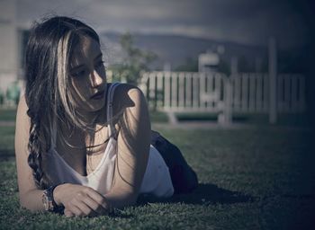 Young woman lying on grassy field