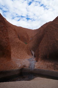 Scenic view of desert against cloudy sky