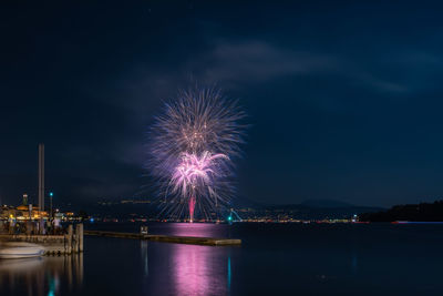 Firework display by sea at night