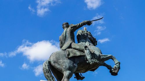 Low angle view of statue against blue sky