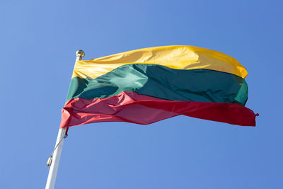 Low angle view of flag against clear blue sky