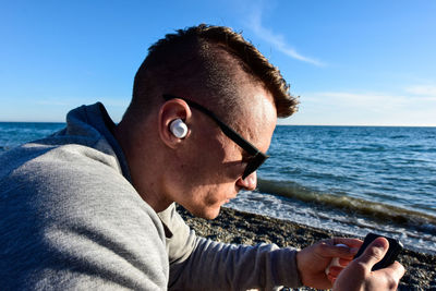 Close-up of man listening to music at beach
