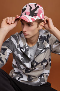 Portrait of boy looking away while sitting against wall