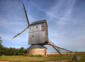 Traditional windmill on field against sky